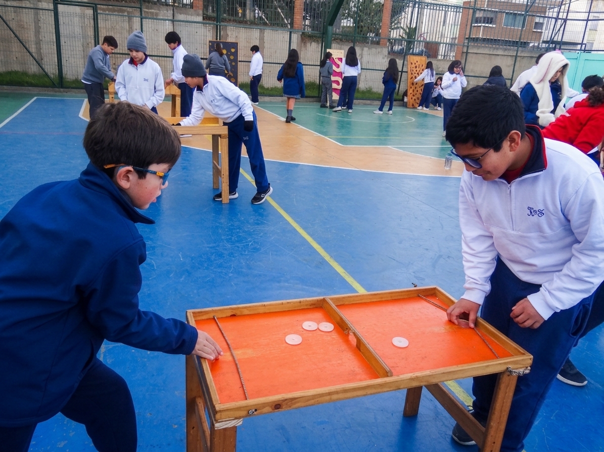 Niños jugando Jenga en patio de colegio